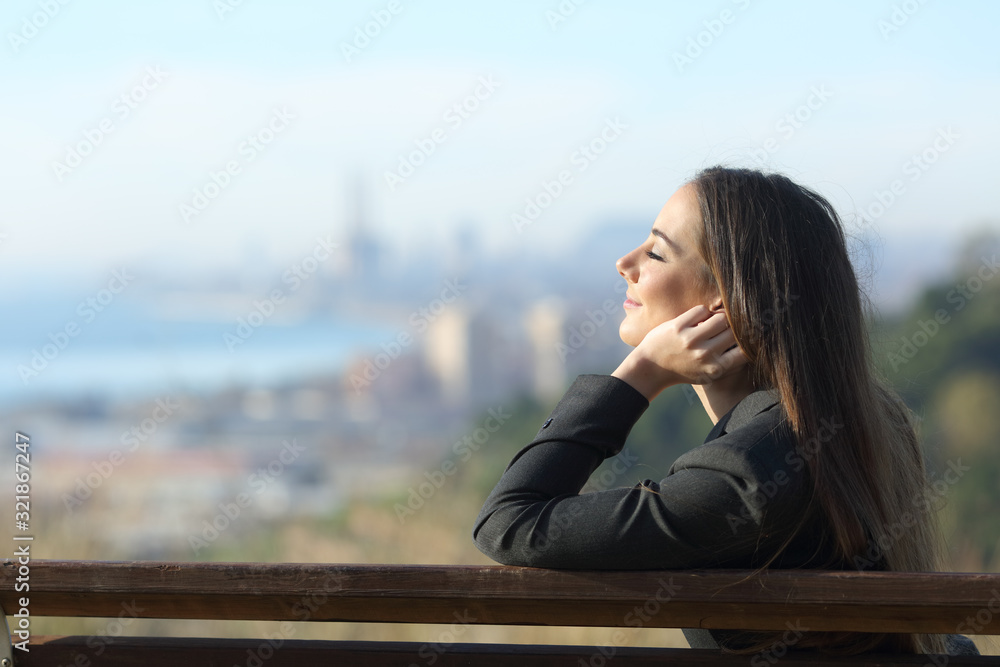 Businesswoman relaxing on a bench with eyes closed