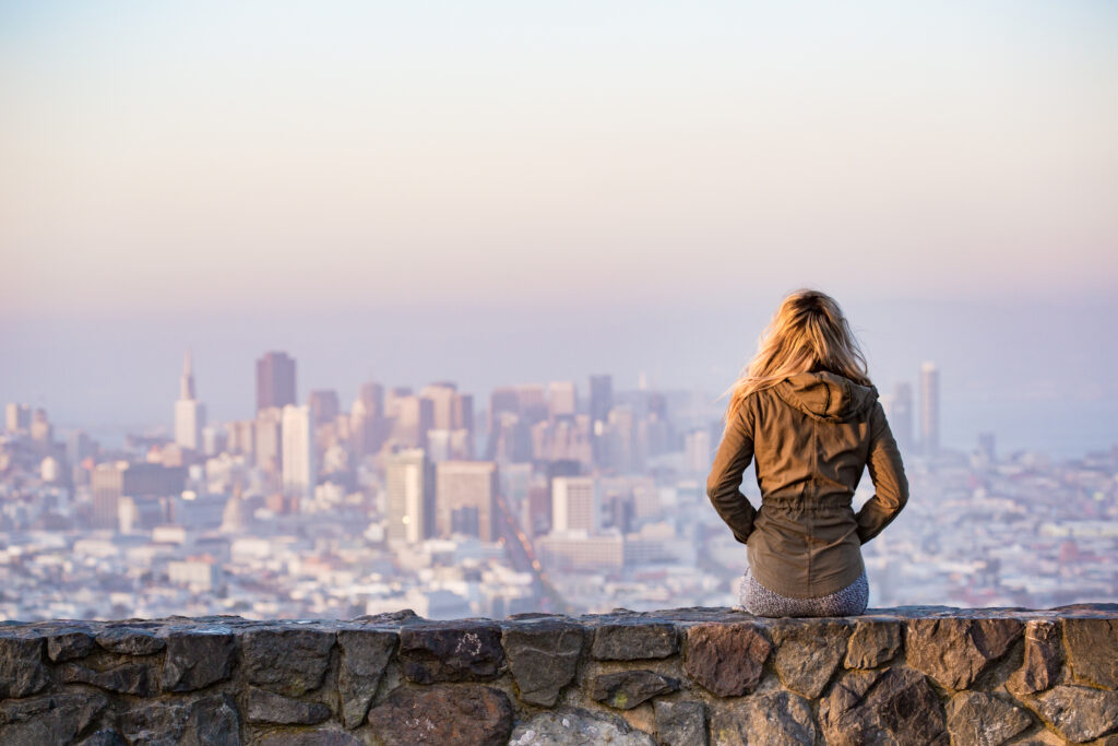 Woman on rock platform viewing city